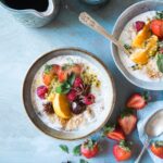 Bowls of overnight oats topped with roasted almonds and dried cranberries