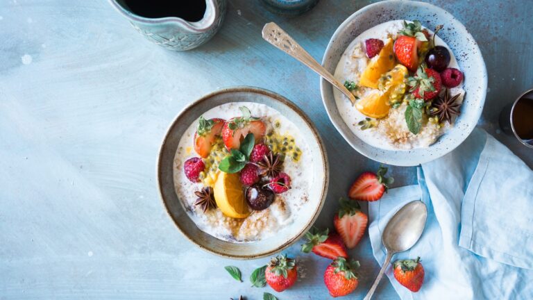 Bowls of overnight oats topped with roasted almonds and dried cranberries