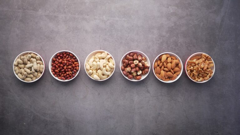 Small bowls comparing serving sizes of different nuts side by side